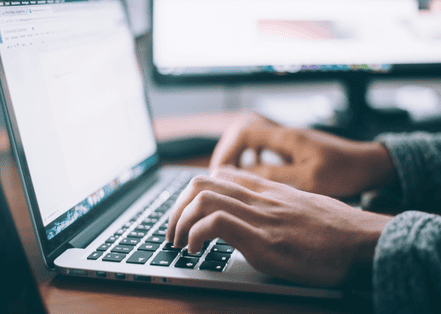 Hands typing on a laptop in a modern workspace, symbolizing digital marketing strategy at DoProFlow.